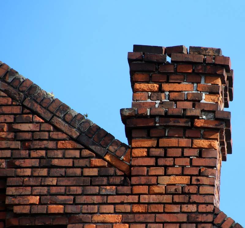 Damaged chimney on an Kendall home showing cracks and missing mortar